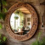 Okrągłe lustro w rzeźbionej drewnianej ramie na tle drewnianej ściany z roślinami i dekoracjami boho